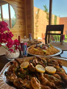 una mesa con tres platos de comida. en كوخ السعاده happiness hut, en Thuwal