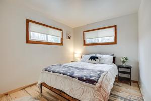 een slaapkamer met een bed en 2 ramen bij Tomahawk Cottage on Somo River Less Than 1 Mi to Lake! in Tomahawk