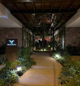 een loopbrug in een gebouw met planten en verlichting bij Villa Andorinha, Apt 03 in Mucugê