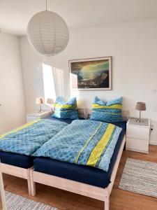 sypialnia z łóżkiem z niebieską kołdrą i poduszkami w obiekcie Helle und gemütliche Ferienwohnung in Lorsch w mieście Lorsch