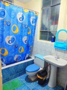 uma casa de banho com uma cortina de chuveiro azul e um WC. em Fernanda apartment em Arequipa