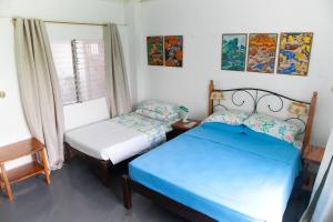 a bedroom with two beds and a window at Villa Elena Guimaras in Buenavista