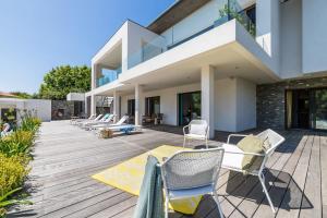 a deck with chairs and a house at LAKEVIEW-KEYWEEK-villa Biarritz - Swimming pool in Biarritz