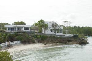 a white house on the shore of a beach at Villa Elena Guimaras in Buenavista