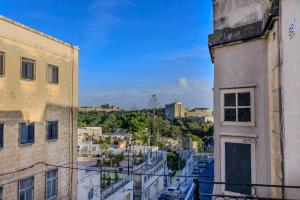 a view of a city from the balcony of a building at The Central guesthouse in Tal-Pietà