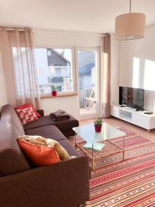 a living room with a couch and a table at Helle und gemütliche Ferienwohnung in Lorsch in Lorsch
