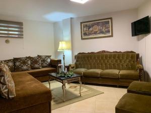 a living room with two couches and a table at TriCalifornia's House in Pýrgos