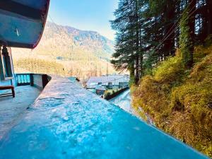a boat traveling down a river with a bridge at WooibHotels The Daulat Manali in Manāli