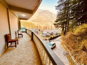un balcón de una casa con vistas a la montaña en WooibHotels The Daulat Manali en Manāli