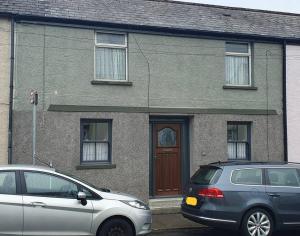 two cars parked in front of a house at 2 bed gem on the riverbank 15 mins from Cardiff centre in Cardiff