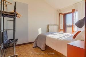 a bedroom with a bed and a chair and a window at Il Convivio in Otricoli