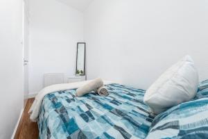 a bed with a blue and white blanket and pillows at Central London Serviced Apartment - Paddington Luxury Stay - Hyde Park & Westminster in London