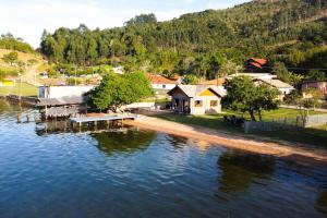 an aerial view of a house on the shore of a lake at Chalé Sol Nascente in Imaruí