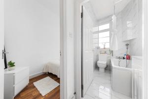 a white bathroom with a toilet and a sink at Central London Serviced Apartment - Paddington Luxury Stay - Hyde Park & Westminster in London