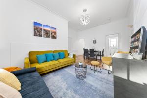 a living room with a yellow couch and a table at Central London Serviced Apartment - Paddington Luxury Stay - Hyde Park & Westminster in London