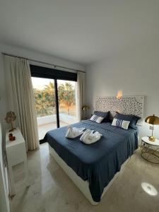 a bedroom with a large bed with blue sheets and a window at Penthouse Golf lujo, Perla Sol 1 in Vera