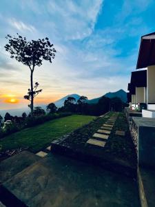 a view of the sunset from a house with a tree at Bali Sunrise Cabin in Bangli