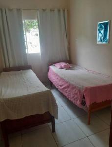 een slaapkamer met 2 bedden en een raam bij Sítio no interior de MG, lugar de sossego e paz! in São Domingos do Prata