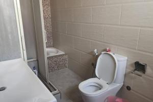 a bathroom with a white toilet and a sink at 3 bedroom apt excellent location near to malls in Cairo