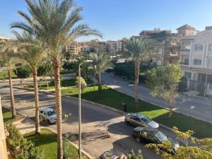 a view of a street with palm trees and cars at 3 bedroom apt excellent location near to malls in Cairo