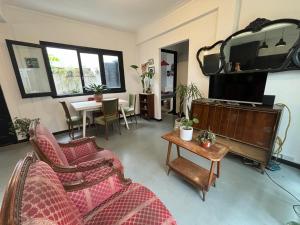 a living room with a couch and a table and a tv at Departamento temporal para 4 personas in Mar del Plata