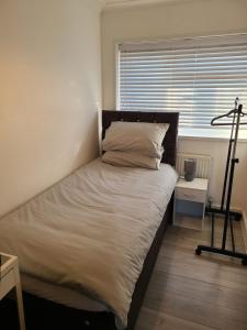 een groot bed in een kamer met een raam bij GATWICK SINGLE ROOM. (GR3). West Sussex in Ifield