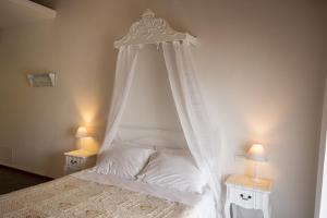1 dormitorio con 1 cama blanca con dosel en B&B Il Barsot, en Pettenasco