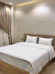 1 dormitorio con 1 cama grande con sábanas blancas en شقه فندقيه مستقله بالشيخ زايد en Sheikh Zayed