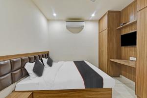 a bedroom with a bed and a television at Townhouse 893 The Circle Rajapark in Jaipur