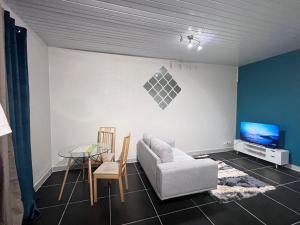 sala de estar con sofá y mesa en Sermie T2 climatisé avec piscine en Kourou