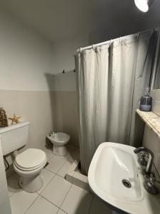 a white bathroom with a toilet and a sink at Departamento temporal para 4 personas in Mar del Plata