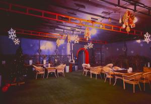 a dining room with tables and chairs and christmas decorations at Aperol Hotel in Tashkent
