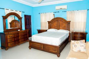 a bedroom with a bed and a dresser and a mirror at DokHomes in Ashalebotwe