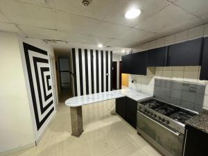 y cocina con encimera y fogones. en Fancy Partition Room Near Mashreq Metro / SZ Road en Dubái