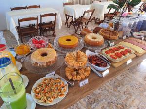 una mesa con muchos tipos diferentes de comida en ella en Hotel Sulmar, en Tramandaí