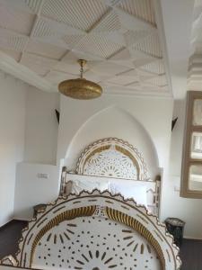 Cama en habitación con techo artesonado en Riad Marrakeshkesh, en Marrakech