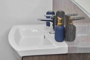 a bathroom sink with two soap bottles on it at 3 Beds - Perfect for Family & Work Relocations in Leeds