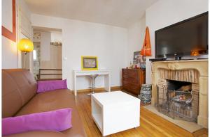 a living room with a couch and a fireplace at APPARTEMENT QUARTIER MONTMARTRE in Paris