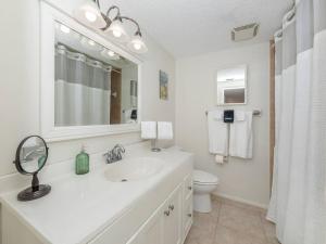 Un baño blanco con lavabo y espejo. en Alligator Escape - Heated pool haven just minutes from Venice beaches, en Venice