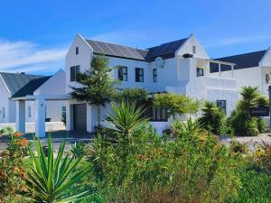 a white house with solar panels on the roof at Frank's Place in Yzerfontein