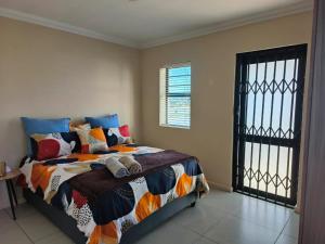 a bedroom with a bed and a black gate at Frank's Place in Yzerfontein