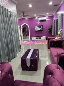 a living room with purple walls and purple furniture at ARY&ZZ Homestay for islam guests in Tanjung Karang