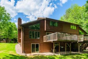a log cabin with a deck and grass at Green Bay Cozy home, 3 bed rooms, 6 beds, 2 bath in Green Bay