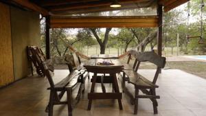 a wooden table and chairs in a screened porch at las tacanas casa del alto in Nono