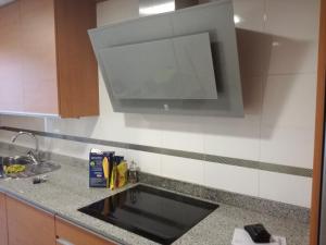 a kitchen counter with a sink and a microwave at Habitacion con Piscina y Sauna in Sant Cugat del Vallès