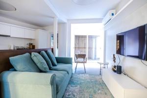 a living room with a blue couch and a tv at Historic Town Cascais Modern Apartment in Cascais