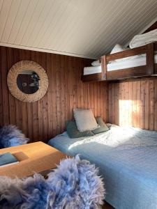 1 dormitorio con 2 camas y espejo en Typisk norsk off-grid hytte opplevelse, en Levanger