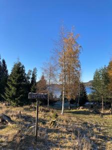 una señal en medio de un campo junto a un lago en Typisk norsk off-grid hytte opplevelse, en Levanger