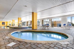 una gran piscina cubierta en un edificio con mesas y sillas en Camelot by the Sea - Oceana Resorts Vacation Rentals, en Myrtle Beach