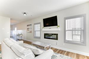 a living room with two white couches and a tv at Modern Greer Retreat Walk to Historic Downtown! in Greer